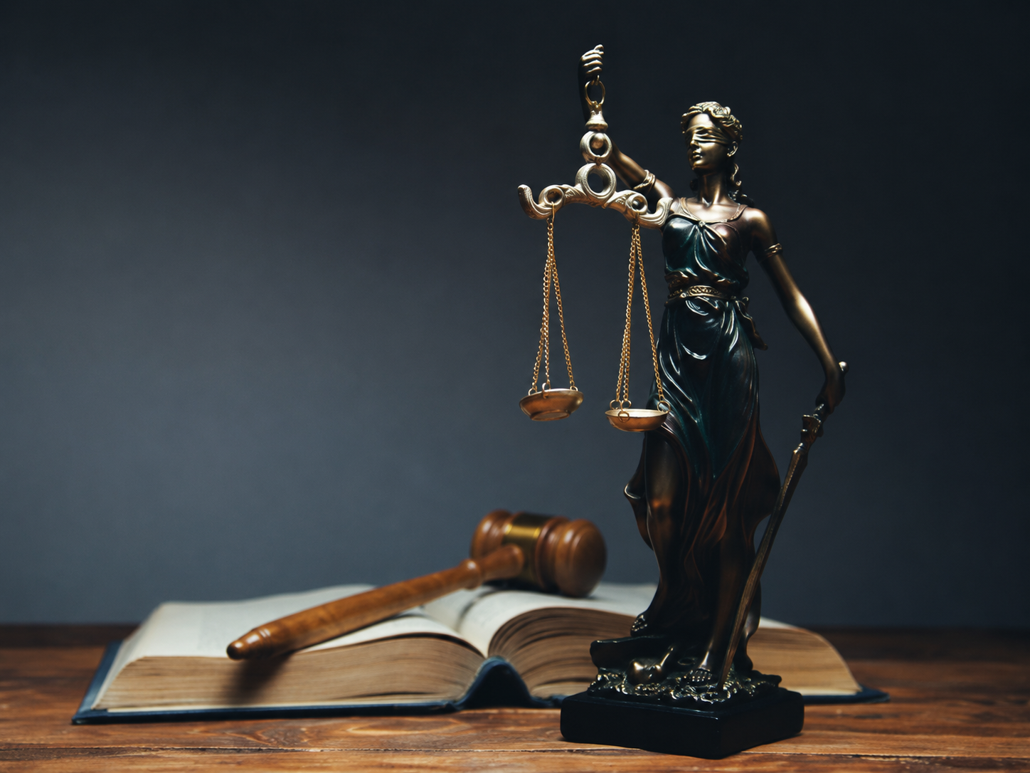 Lady Justice statue, gavel, and legal book